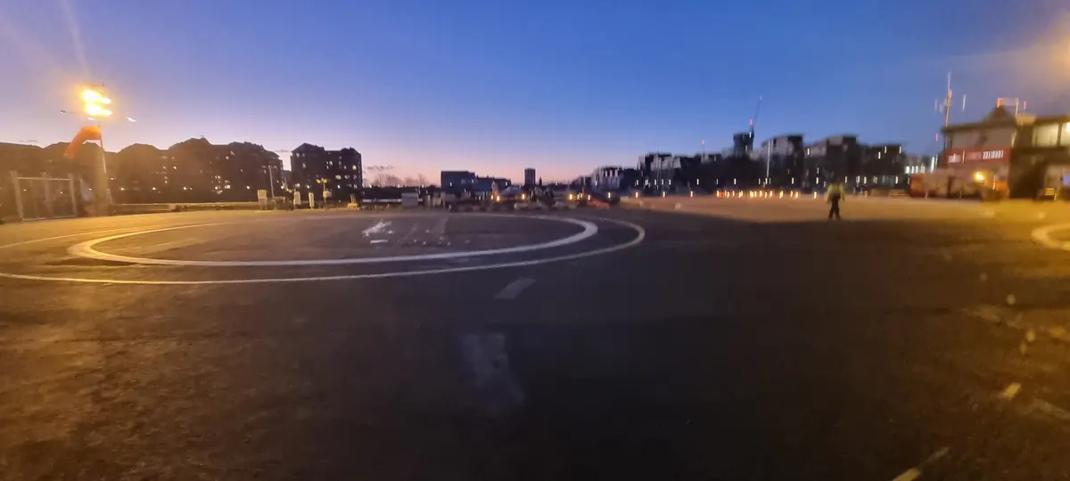 A helipad at dusk with a ring of small lights marking its edge